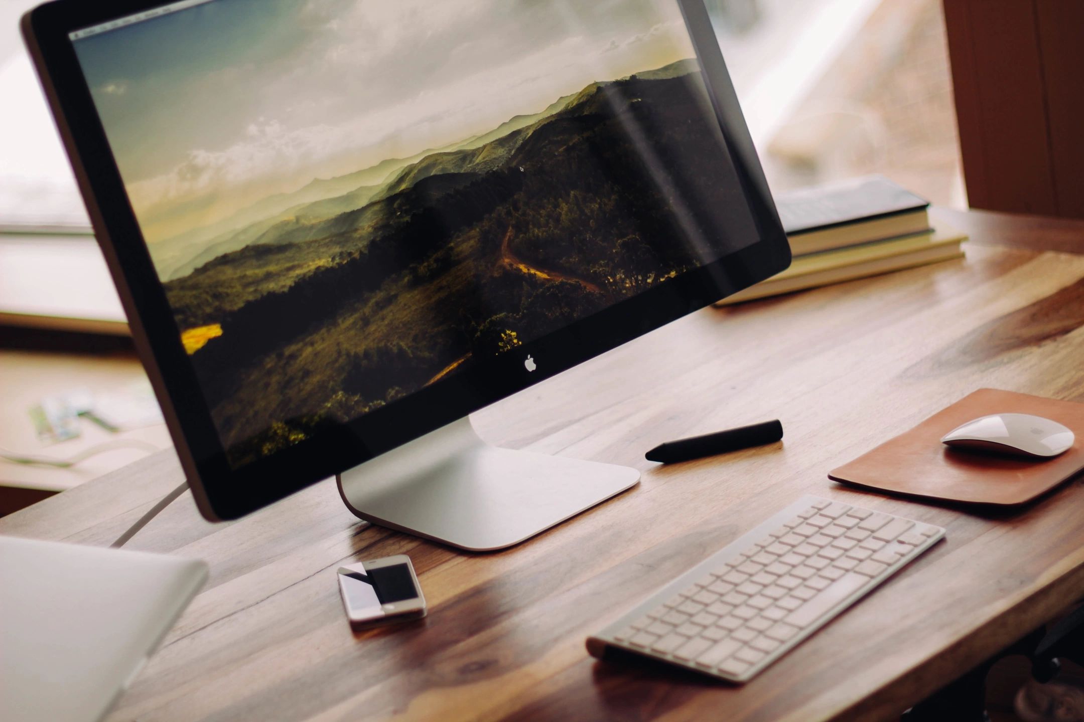 Desktop computer, keyboard and mouse on a wooden desk